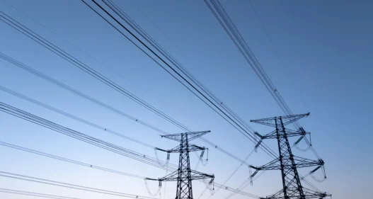 Power pylons under sunset sky - stock photo