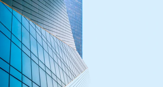 Modern glass skyscraper building reflecting blue sky - stock photo