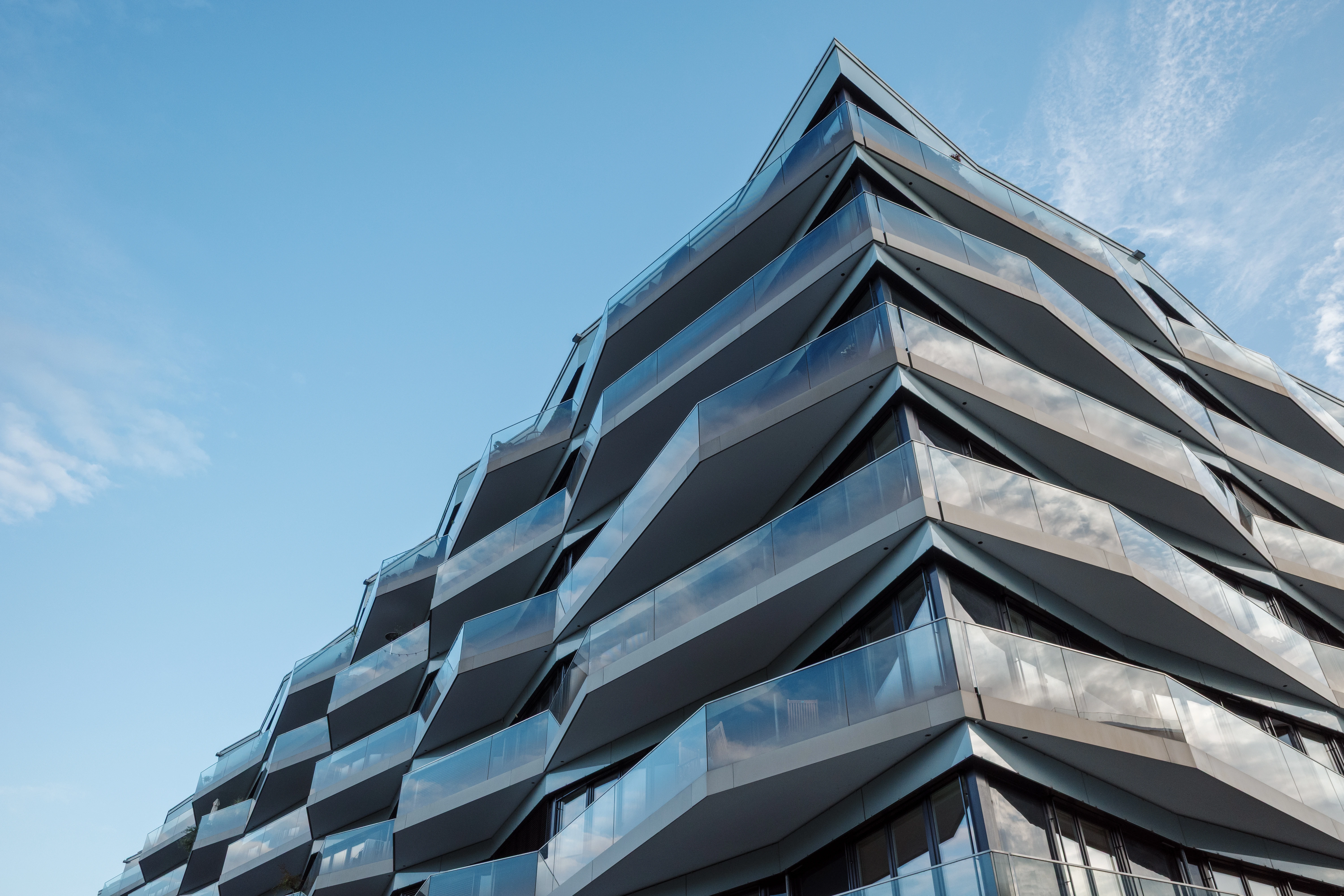 The unique architecture features a dynamic, crystalline structure with sharp, angular balconies and blue-tinted glass - stock photo