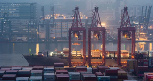 Cranes loading containers at a port - stock photo