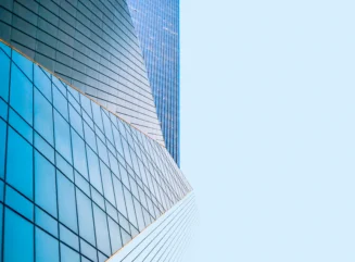 Modern glass skyscraper building reflecting blue sky - stock photo